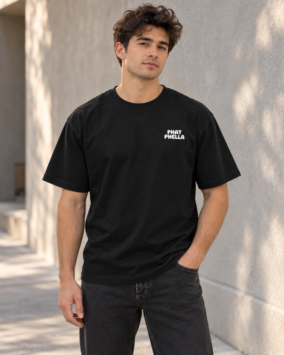 Custom lifestyle mockup of the black Powder the Soul Reaper tee, showing the small white Phat Phella logo on the front left chest.